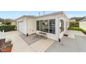 Home featuring a one-car garage and inviting sunroom addition for extra living space at 17454 Se 81St Newberry Ct, The Villages, FL 32162