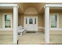 Inviting front porch with columns, seating, and decorative door wreath at 11053 Se 174Th Loop, Summerfield, FL 34491