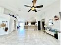 Spacious living room featuring vaulted ceilings, light tile floors, and an open floor plan to the kitchen at 1209 Demoiselle St, Groveland, FL 34736