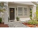 Welcoming front porch with decorative wreath, lush plants and stylish exterior lighting at 1212 Windy Bluff Dr, Minneola, FL 34715