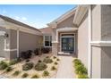 Inviting front entrance with double doors, a covered porch, and manicured landscaping at 13146 Se 91St Court Rd, Summerfield, FL 34491