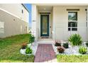 Inviting front entrance with a well-manicured garden and brick path leading to the home at 140 S Zuni Rd, St Cloud, FL 34771