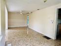 View of the living room with a ceiling fan and a hallway leading to another room and marble-style floors at 15747 Old Highway 50, Clermont, FL 34711