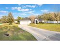 Inviting home with a two-car garage, a curved driveway, and a manicured lawn, creating a welcoming curb appeal at 1603 Brookstone Ln, Fruitland Park, FL 34731