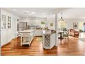 Bright kitchen with white cabinetry, an island, stainless steel appliances, and hardwood floors at 1622 Valley Falls Way, The Villages, FL 32162