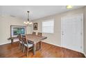 Dining room featuring hardwood floors, chandelier, and rustic wooden table with 4 chairs at 16865 Se 94Th Sunnybrook Cir, The Villages, FL 32162