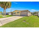 Single-story home with bright green front lawn, concrete driveway, and covered carport at 1854 W Schwartz Blvd, Lady Lake, FL 32159