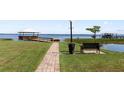 Scenic lakeside park with a picturesque walkway, wooden bench, and covered dock for enjoying the waterfront views at 2229 Cypress Ct # C-4, Tavares, FL 32778