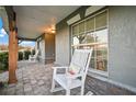 Inviting front porch featuring brick accents, comfortable rocking chairs, and a cozy atmosphere at 2289 Se 110Th Ave, Webster, FL 33597