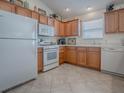 Functional kitchen with oak cabinets and white appliances, offering a practical space for cooking and meal preparation at 2367 Camden Ter, The Villages, FL 32162