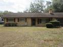 Quaint single-story brick home with well-kept shrubbery enhancing its curb appeal at 2416 Spring Lake Rd, Fruitland Park, FL 34731