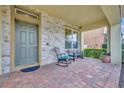 Inviting front porch with stone accents, brick paving, and seating, offering a cozy outdoor space at 2727 Retriever Dr, Clermont, FL 34711