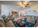 Open-concept living room with a cozy sofa, kitchen island and tile flooring at 3339 Landing Vw, Tavares, FL 32778