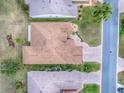 An aerial view of a charming home featuring a brick driveway, well-kept lawn, and a neatly designed roof at 33409 Pennbrooke Pkwy, Leesburg, FL 34748