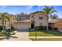 Charming two-story home with a well-maintained lawn, two car garage, and beautiful tropical landscaping at 412 Arbor Pointe Ave, Minneola, FL 34715