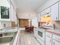 Bright kitchen with white cabinets and appliances flowing into the dining area at 4918 County Road 114, Wildwood, FL 34785