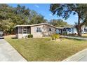 Charming home with a well-manicured lawn and a inviting screened-in porch at 520 Saint Andrews Blvd, The Villages, FL 32159