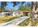 Beautiful house with a manicured lawn, covered parking, and a charming walkway at 520 Saint Andrews Blvd, The Villages, FL 32159