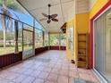 Spacious screened porch with tile floors, ceiling fan, and views of the backyard at 600 Arlington Ct, Eustis, FL 32726