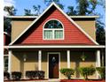 Lovely front exterior featuring a stained wood door and manicured landscaping at 600 Urick St, Fruitland Park, FL 34731