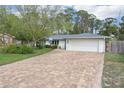 Single story home with a brick driveway, a garage, and a manicured front yard at 700 Azalea Ct, Mount Dora, FL 32757