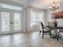 Formal dining room with tile floors, modern chandelier, and glass doors leading to the outside at 9052 Se 130Th Loop, Summerfield, FL 34491