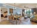 Bright living area showcasing a dining set, large window, and blue furnishings for a comfortable living space at 907 Charo Pkwy # 915, Davenport, FL 33897
