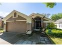 Inviting single-story home featuring a two-car garage, screened front entry, and well-kept landscaping at 10910 Rushwood Way, Clermont, FL 34714