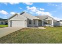 Inviting single-story home with neat landscaping and a two-car garage at 12050 Ne 51St Cir, Oxford, FL 34484