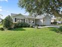 Inviting single-story home with green lawn, mature tree, and neutral siding, creating a serene curb appeal at 1414 Georgetown Ave, The Villages, FL 32162