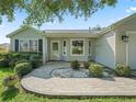 Close-up of the home's entrance showing a patterned brick walkway and quaint landscaping at 1414 Georgetown Ave, The Villages, FL 32162