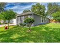 Low angle view of single-story home exterior with well-manicured lawn and mature landscaping at 1511 Whooping Dr, Groveland, FL 34736