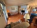Cozy living room with laminate floors, ceiling fan, and view to the kitchen at 1532 W Schwartz Blvd, Lady Lake, FL 32159