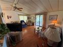 Comfortable living room with a ceiling fan, slider to lanai, and warm natural light at 1532 W Schwartz Blvd, Lady Lake, FL 32159