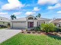 Inviting home with a brick driveway, lush green lawn, mature landscaping, and a two-car garage at 17504 Se 119Th Cir, Summerfield, FL 34491
