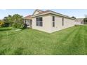 Spacious backyard with green lawn, ideal for outdoor activities and relaxation, with screened patio in view at 1904 Augustine Dr, The Villages, FL 32159