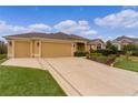 Spacious home with a large driveway leading to an attached two-car garage at 1938 Sassparilla Way, The Villages, FL 32162