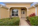 Inviting front porch features a cozy seating area and mature landscaping at 1938 Sassparilla Way, The Villages, FL 32162