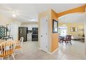 Bright kitchen featuring stainless steel appliances, tile flooring, and a seamless flow into the dining and living areas at 1952 Peachtree Ave, The Villages, FL 32162