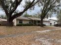 Exterior front view of home with well-kept landscaping and mature trees at 2726 Lakewood Ln, Eustis, FL 32726