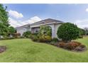 Well maintained single-story home featuring lush landscaping and an attached two-car garage at 2935 Cedar Grove Loop, The Villages, FL 32163