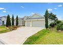 View of a single-story house, showing its manicured lawn, mature landscaping, and three-car garage at 3233 Belcherry Loop, The Villages, FL 32163