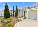 A charming home front yard, adorned with well-manicured greenery and lush plantings at 3233 Belcherry Loop, The Villages, FL 32163