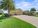 Inviting home with a three-car garage, mature landscaping, and concrete driveway at 3654 Enterprise Dr, The Villages, FL 32163