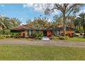 Well-manicured front yard showcasing a charming home with a unique paint job and mature landscaping at 36816 Taylor Mill Rd, Fruitland Park, FL 34731