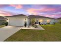 Exterior view of home featuring lush lawn and colorful sunset sky at 4000 Se 98Th Pl, Belleview, FL 34420