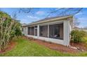 Enclosed back porch with chairs overlooking the well maintained backyard at 4110 Hammersmith Dr, Clermont, FL 34711
