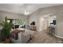 Spacious living room with vaulted ceilings, wood floors and sliding glass doors to the back patio at 5466 Compass Pt # 101, Oxford, FL 34484