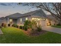 Beautiful home illuminated at dusk with lush landscaping and inviting lighting at 5934 Kaplan Ct, The Villages, FL 32163