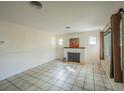 Cozy living room featuring a decorative fireplace, neutral paint, tile floors and natural light at 618 N Grandview St, Mount Dora, FL 32757